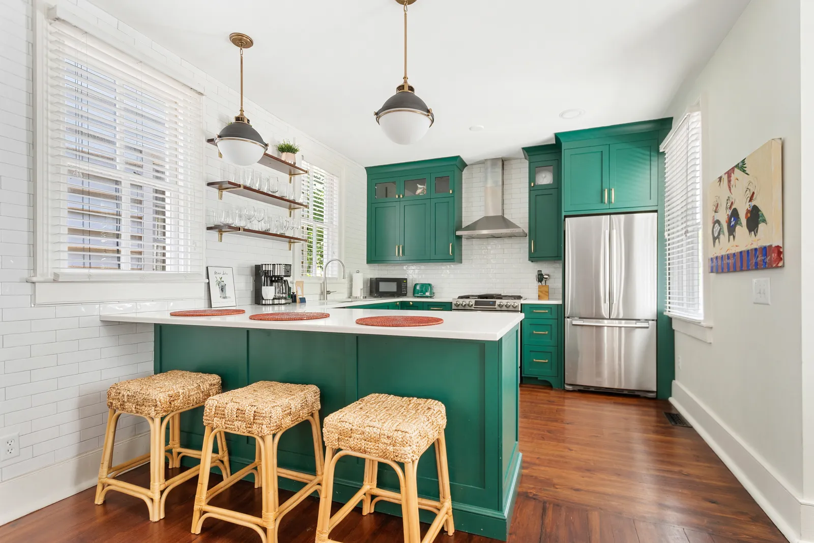 The kitchen island with woven counter stools and pendant lights