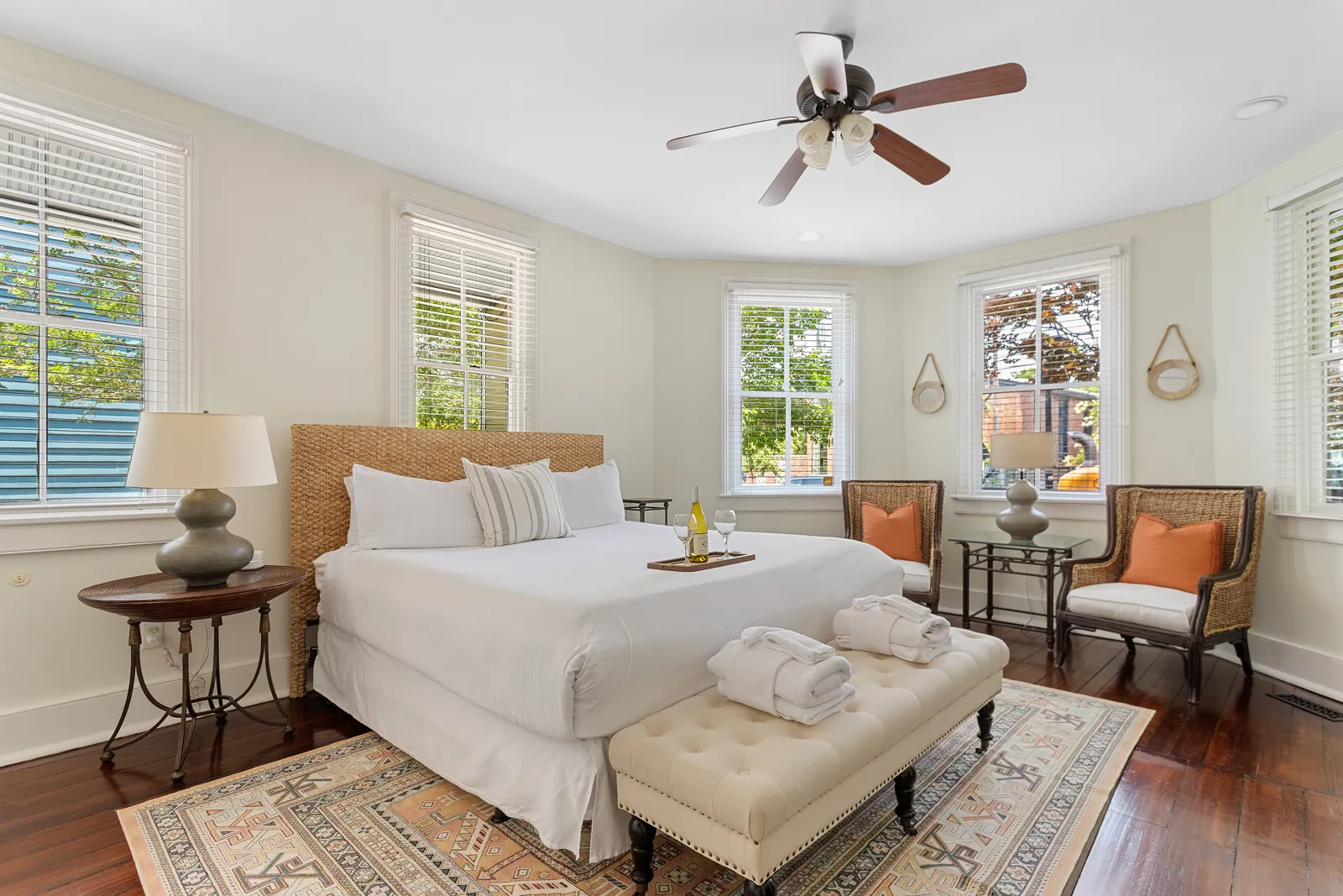 A king bedroom with a woven headboard and sitting chairs