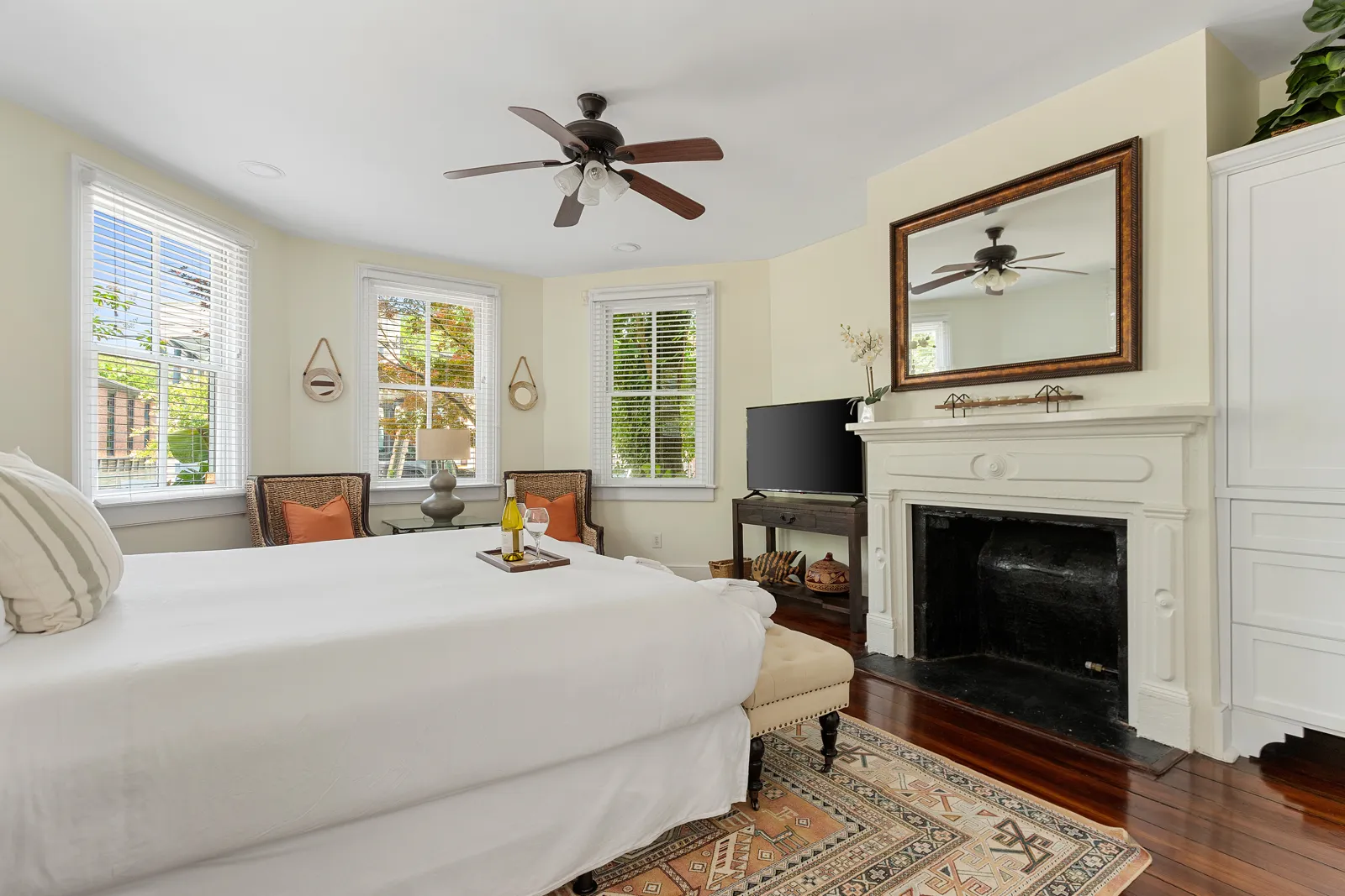 A bedroom with an original fireplace and mantel mirror