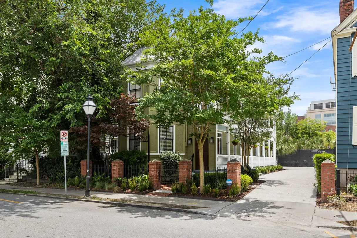 The Mint Julep Residence from the corner of Cannon Street, a historic Charleston home behind a brick and iron fence