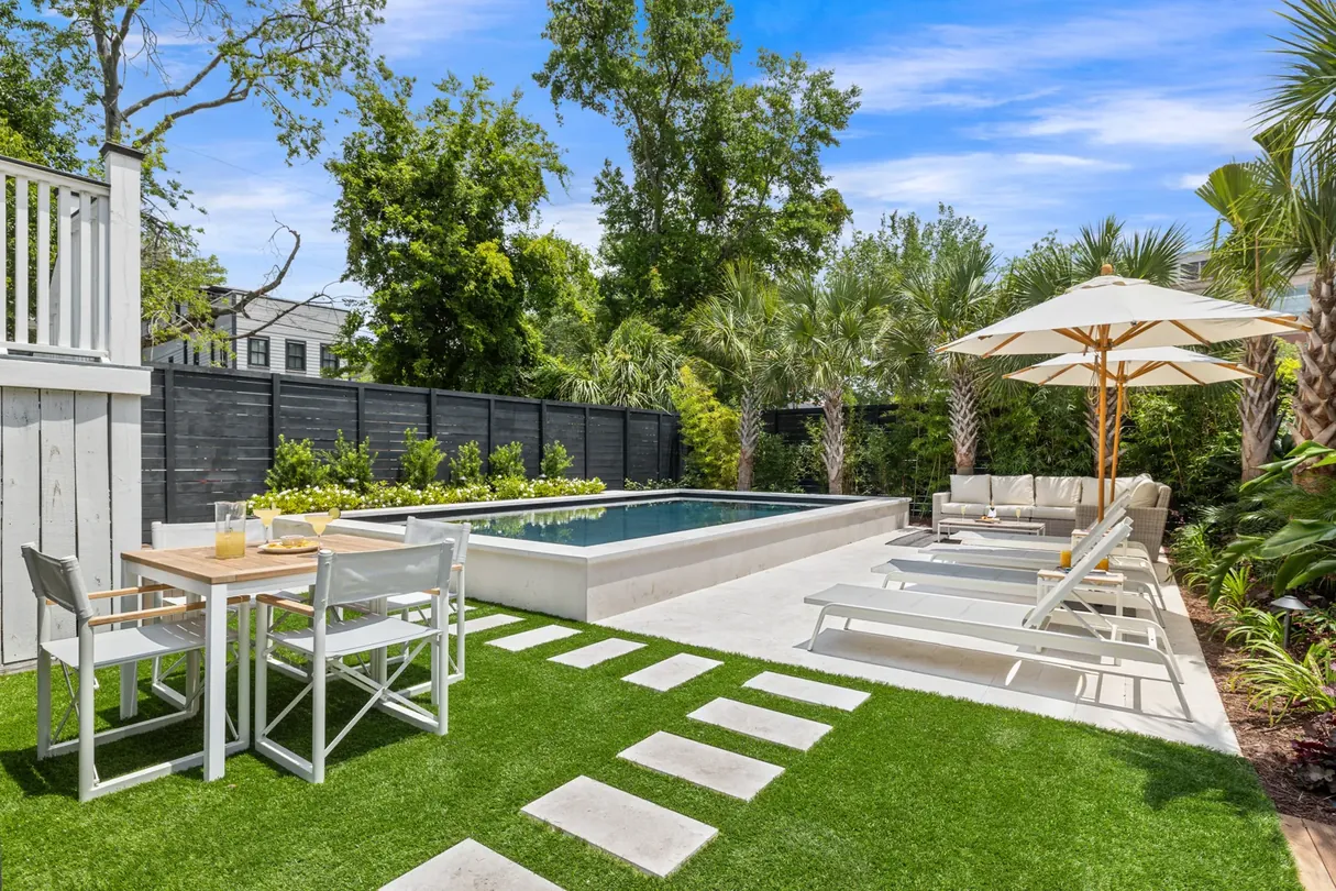 The pool, lawn and outdoor dining table of The Mint Julep Residence