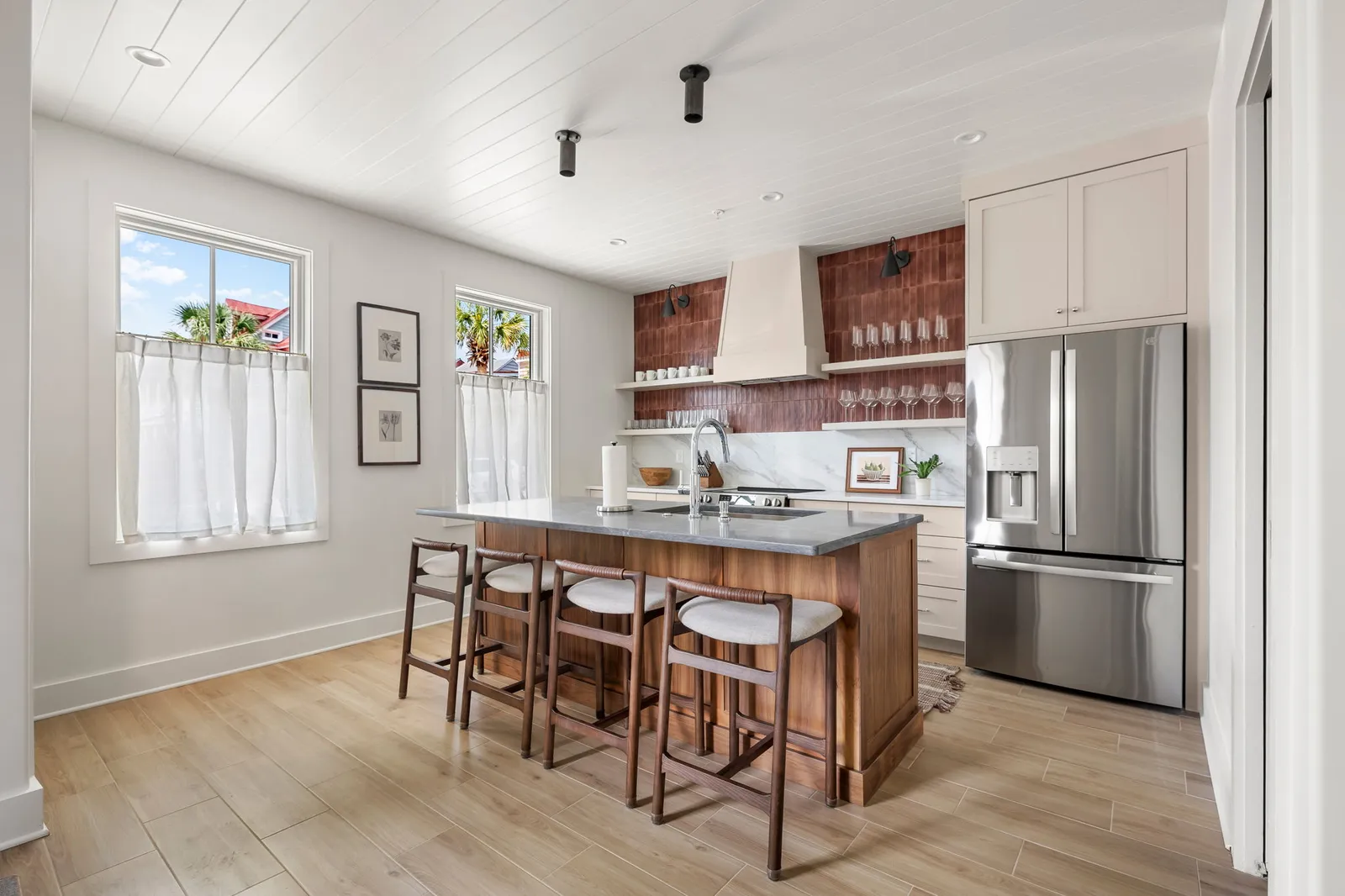 The chef's kitchen with terracotta red tile, island seating and full appliances