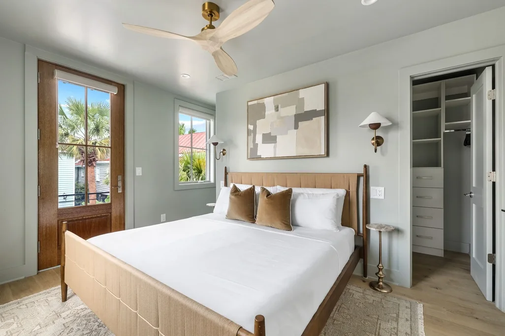 A king bedroom with morning light through the balcony door