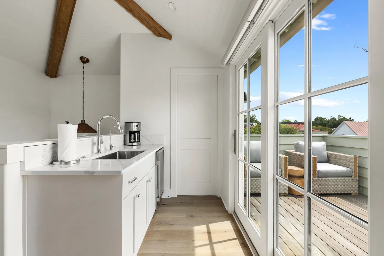 The primary suite kitchenette opening to the rooftop deck