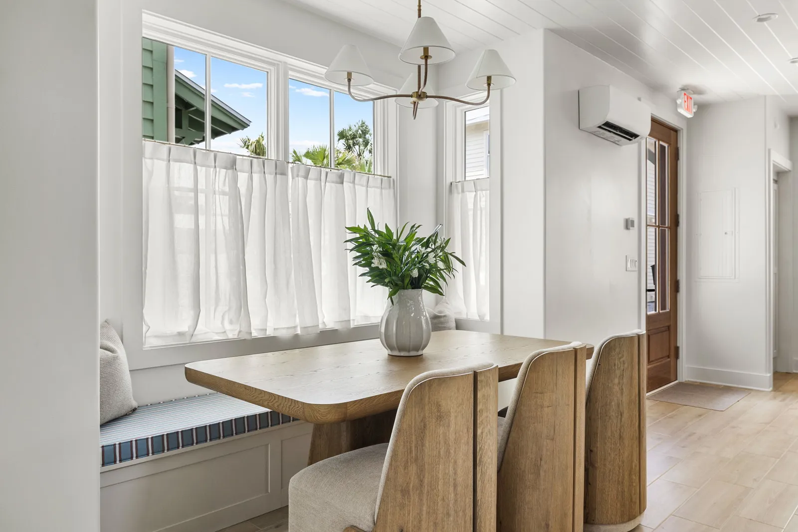 The dining nook with banquette seating under bright windows