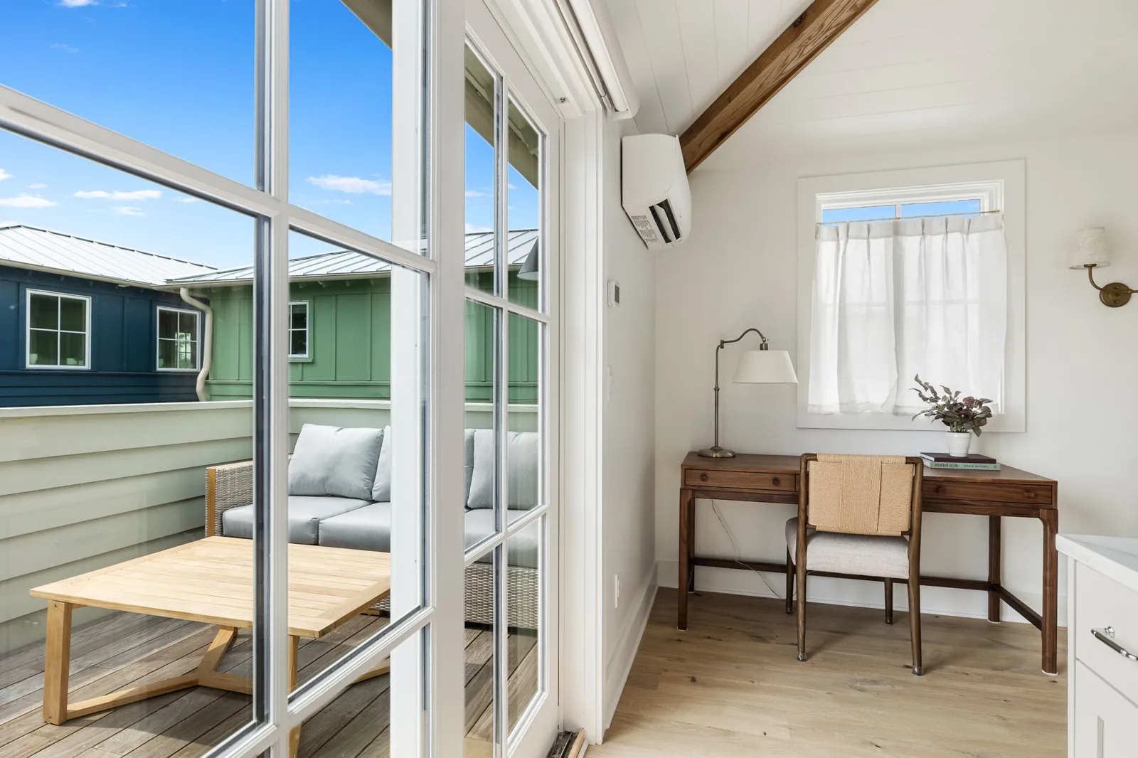 The third floor desk with the rooftop deck through the glass doors