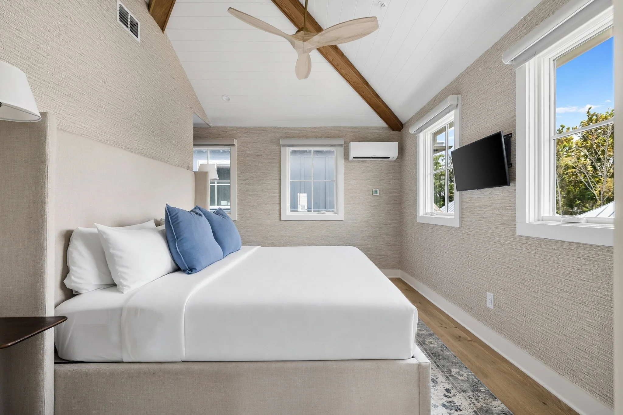 The primary suite in the other residence with grasscloth walls